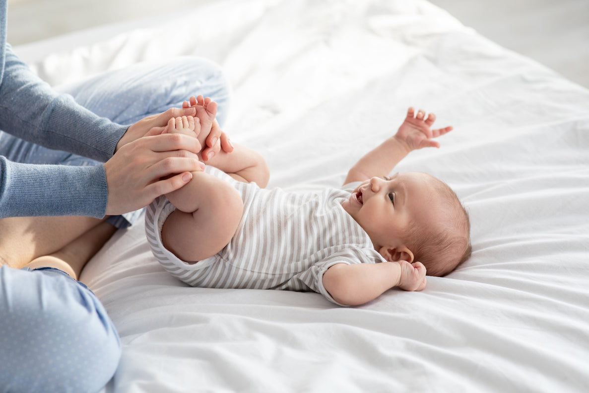 a parent holds a newborn's legs in the