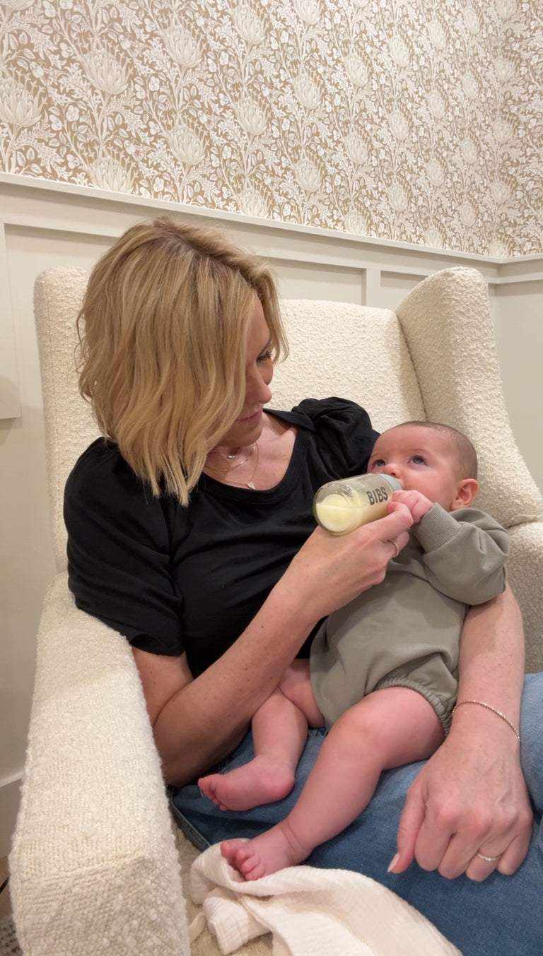 baby being cradled and fed a bottle