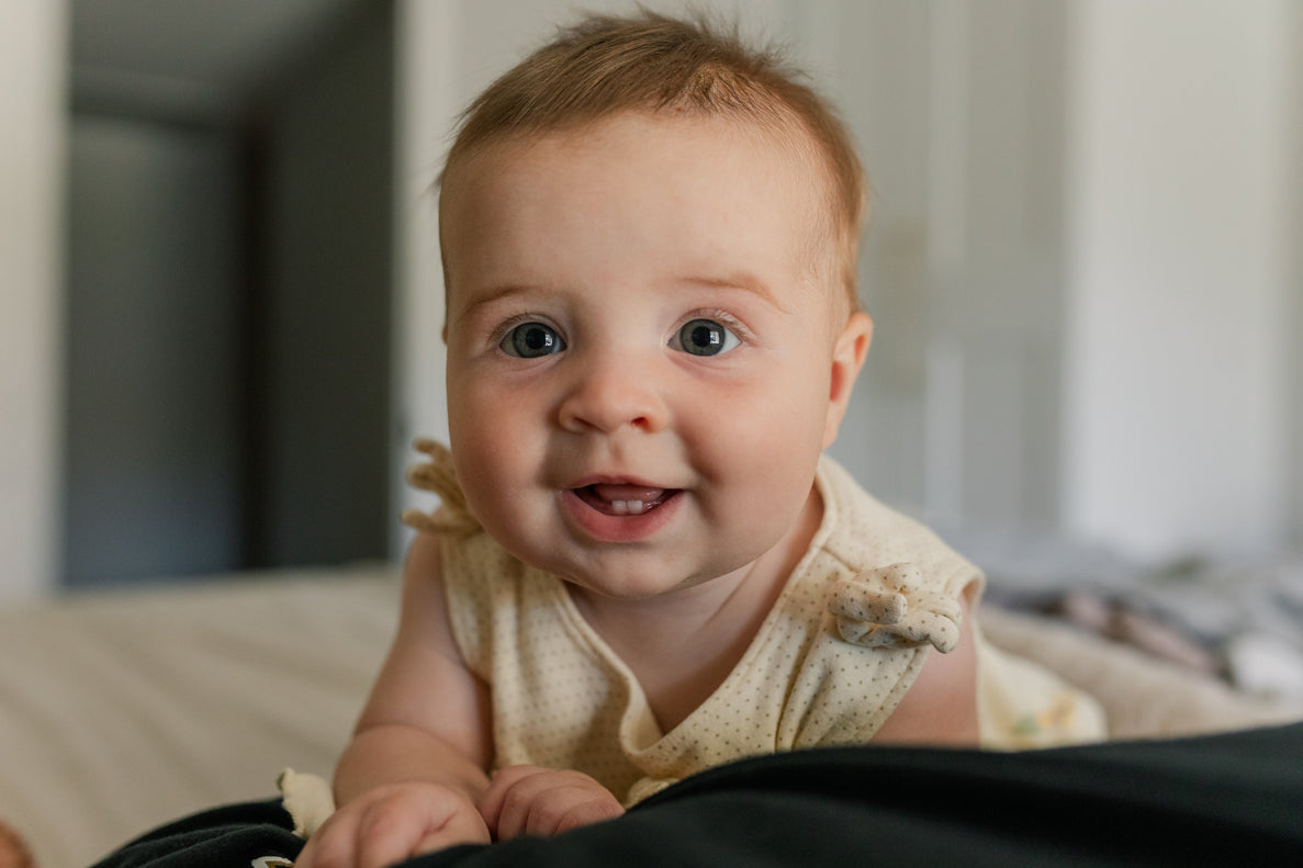 6 month old baby smiling at camera
