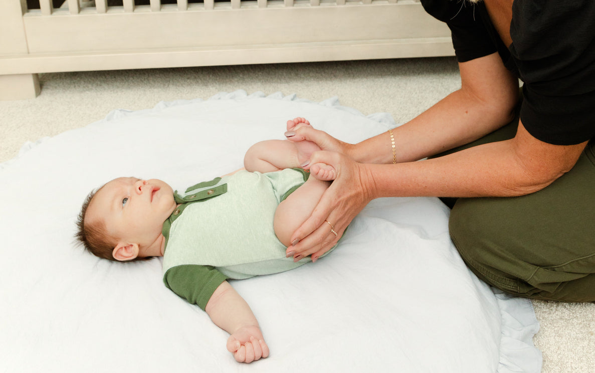 baby on rug with legs in frog position