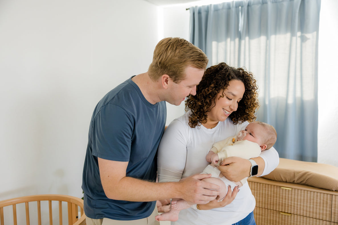 dad and mom gazing at baby in mom's arms
