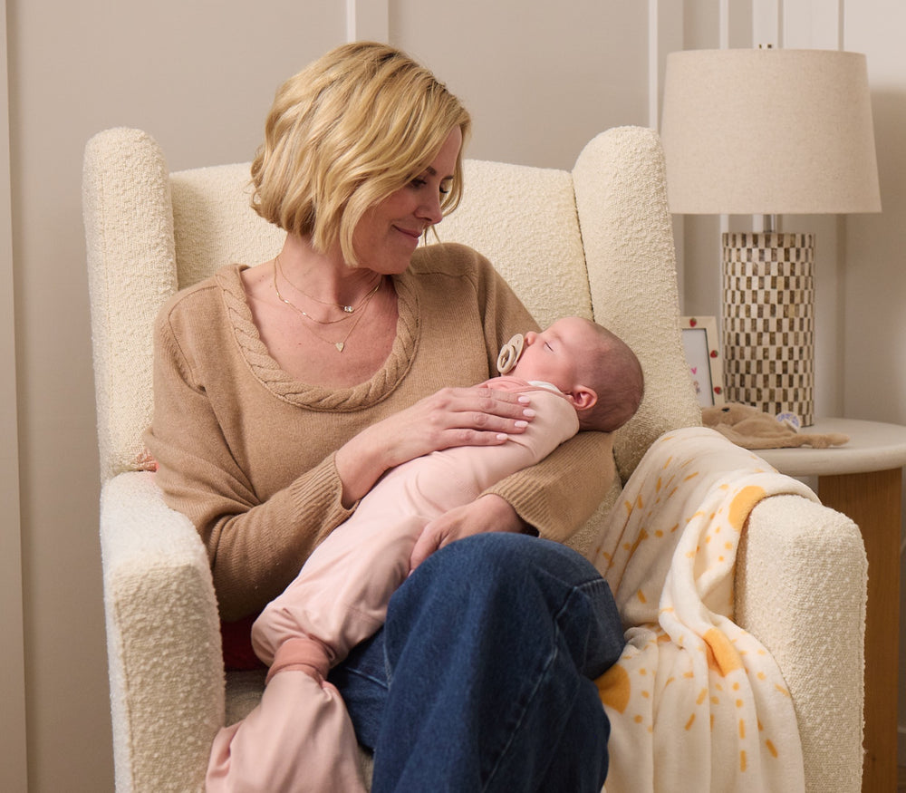 Cara Dumaplin holding a sleeping newborn